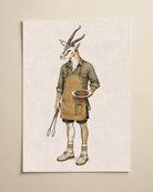A vertical art print featuring a whimsical illustration of a gazelle dressed as a chef, wearing an apron and holding a plate with a burger, displayed on a neutral beige wall.