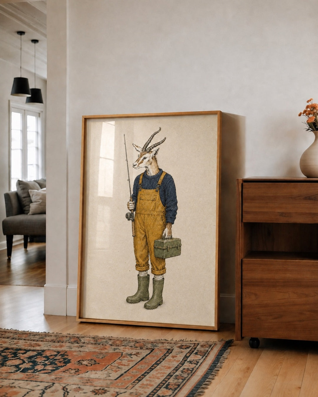 A framed art print featuring a whimsical illustration of a goat dressed as a farmer, standing in a rustic room next to a wooden cabinet.